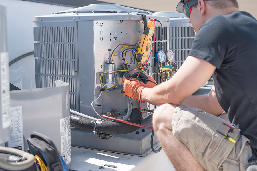 technician repairing commercial building roof unit massapequa ny